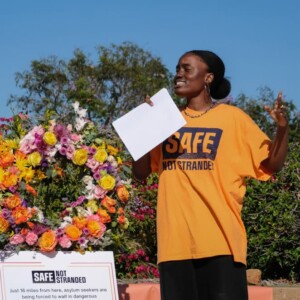 A young woman from Justice Action Center speaks at an event