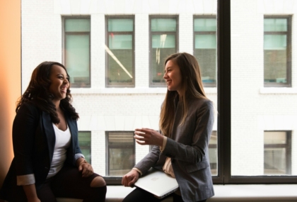 Two colleagues sitting together having a friendly conversation.