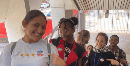 Group of teenagers wearing I Voted stickers, going up an escalator