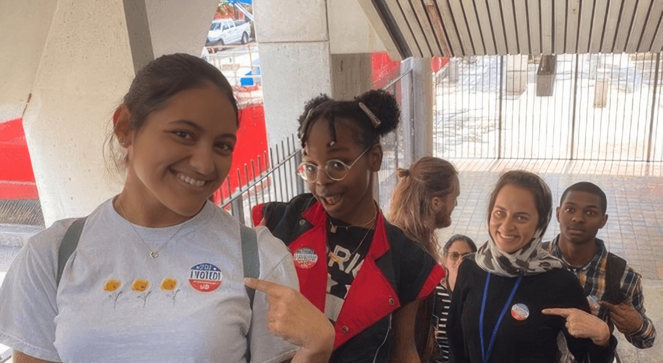 Group of teenagers wearing I Voted stickers, going up an escalator