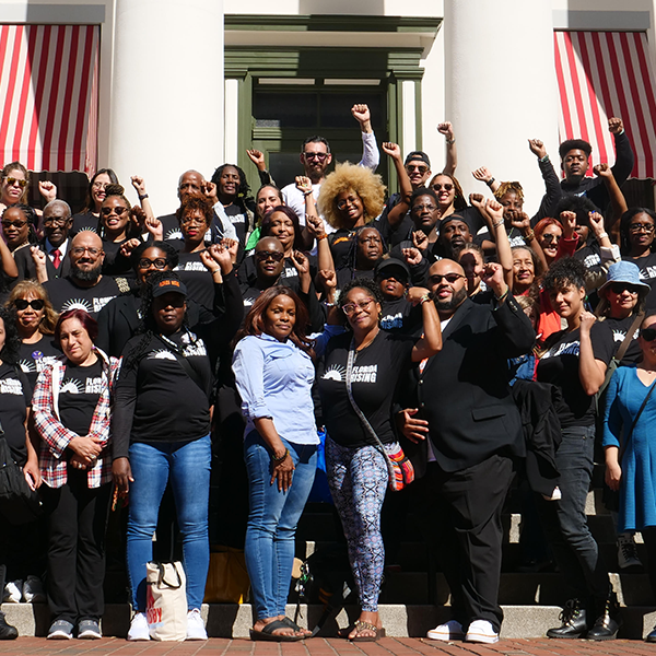 A large multiracial group of people standing together from Florida Rising, some people are raising their fists into the air. Photo credit: Florida Rising, a Tides Healthy Democracy Fund grantee