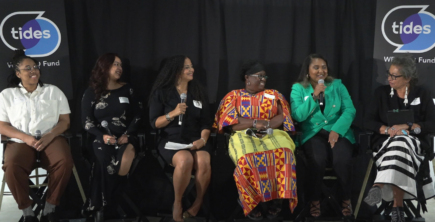 A group of 6 women sitting on tall stools, speaking at a panel discussion